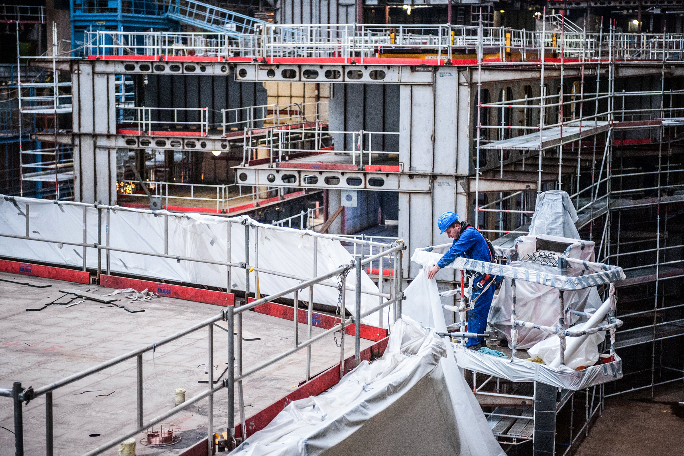 Ein Arbeiter der Meyer Werft hält eine industrielle Plastikabdeckung in der Hand, Papenburg, Deutschland