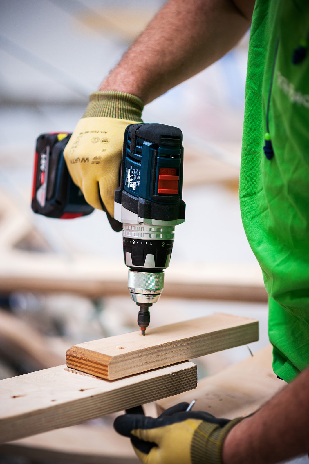 Ein Bauarbeiter bohrt Holzleisten