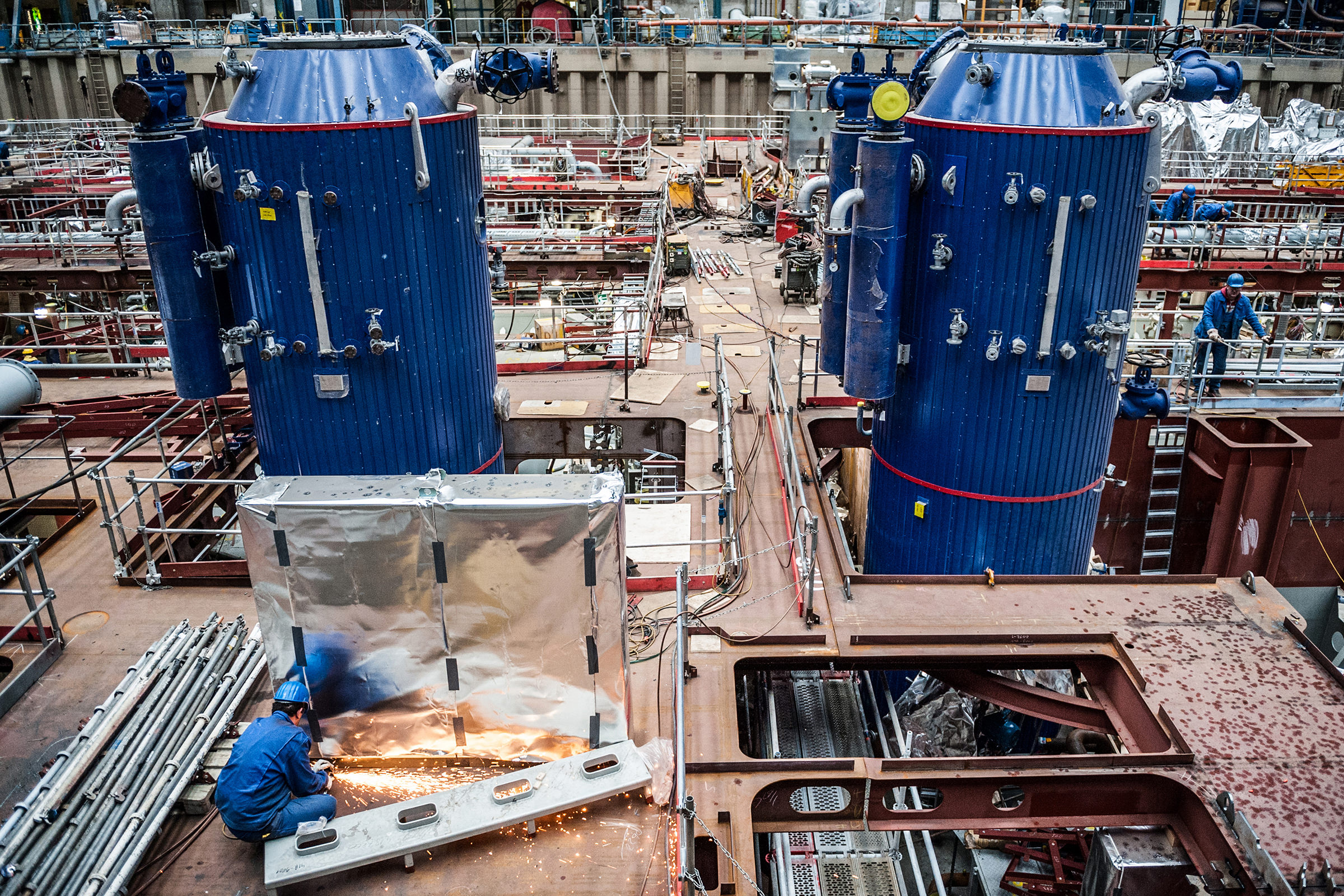 Ein Schweißer der Meyer Werft arbeitet zwischen den Industrieanlagen in einer Halle, Papenburg, Deutschland