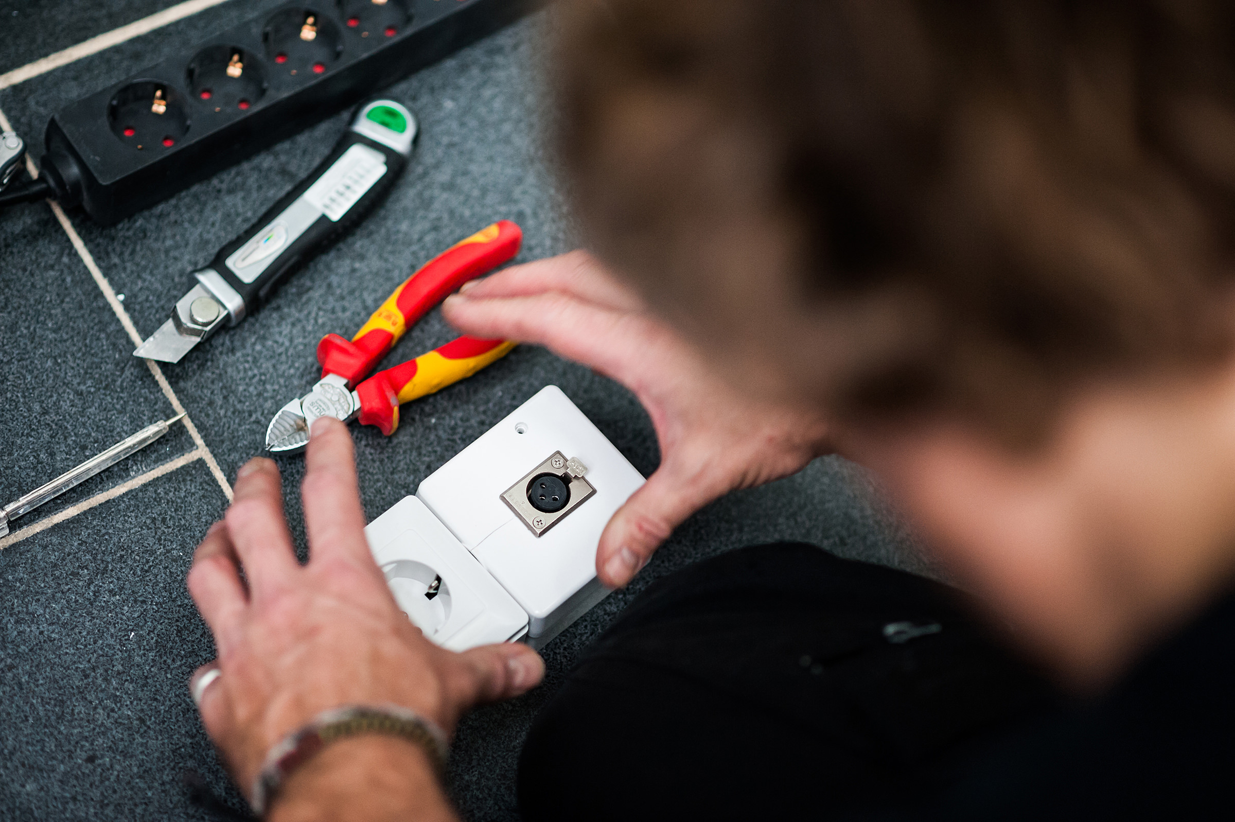 Ein Techniker installiert eine Steckdose mit XLR-Anschluss