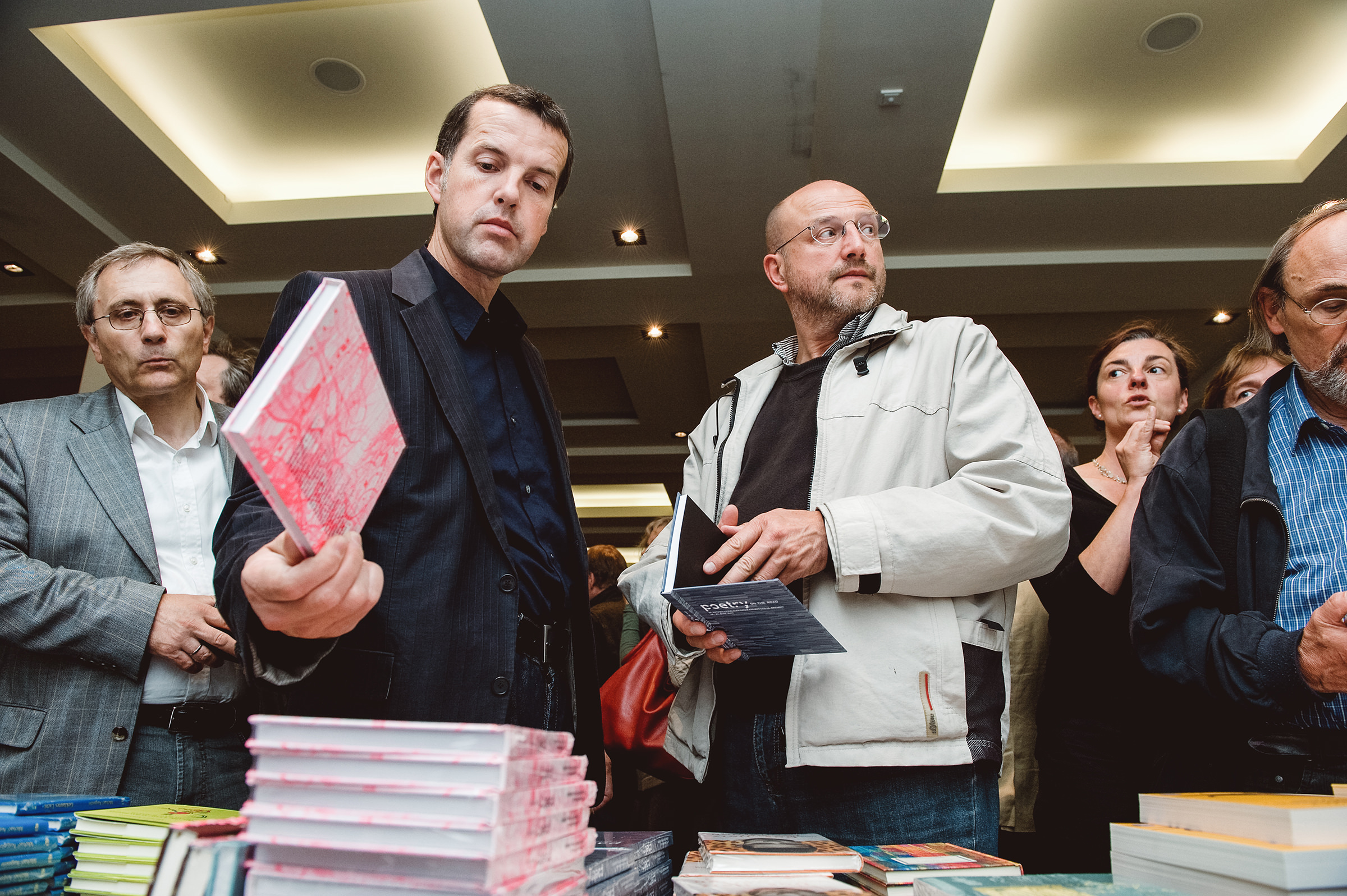 Besucher und Teilnehmer des Internationalen Literaturfestivals Poetry On The Road in Bremen schauen sich Bücher an und werden dabei von einem Eventfotografen fotografiert