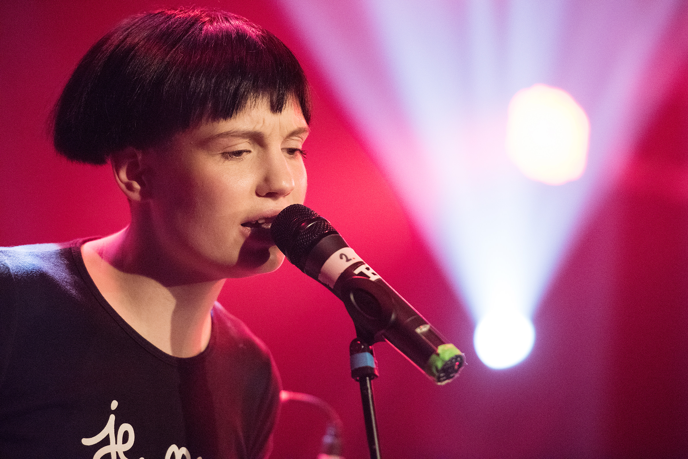 Ein Bild von einem Veranstaltungsfotografen von einer Sängerin, die auf einer Bühne bei einem Event im Konzertsaal Knust in Hamburg singt