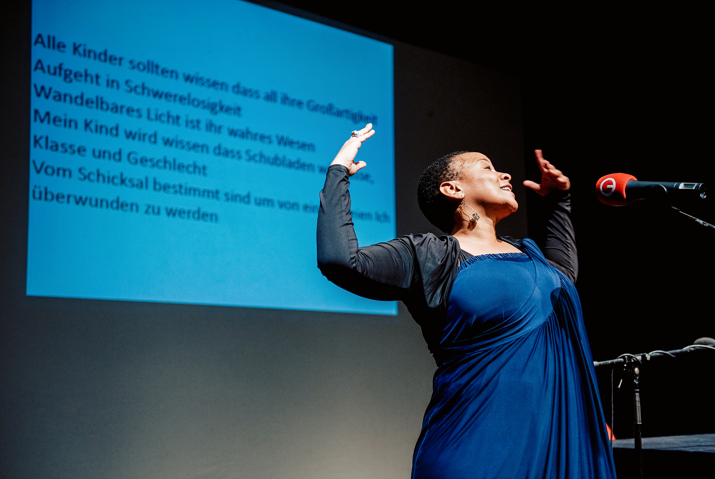 Eine Dichterin liest auf der Bühne im Theatersaal des Internationalen Literaturfestivals Poetry On The Road in Bremen ein Gedicht vor