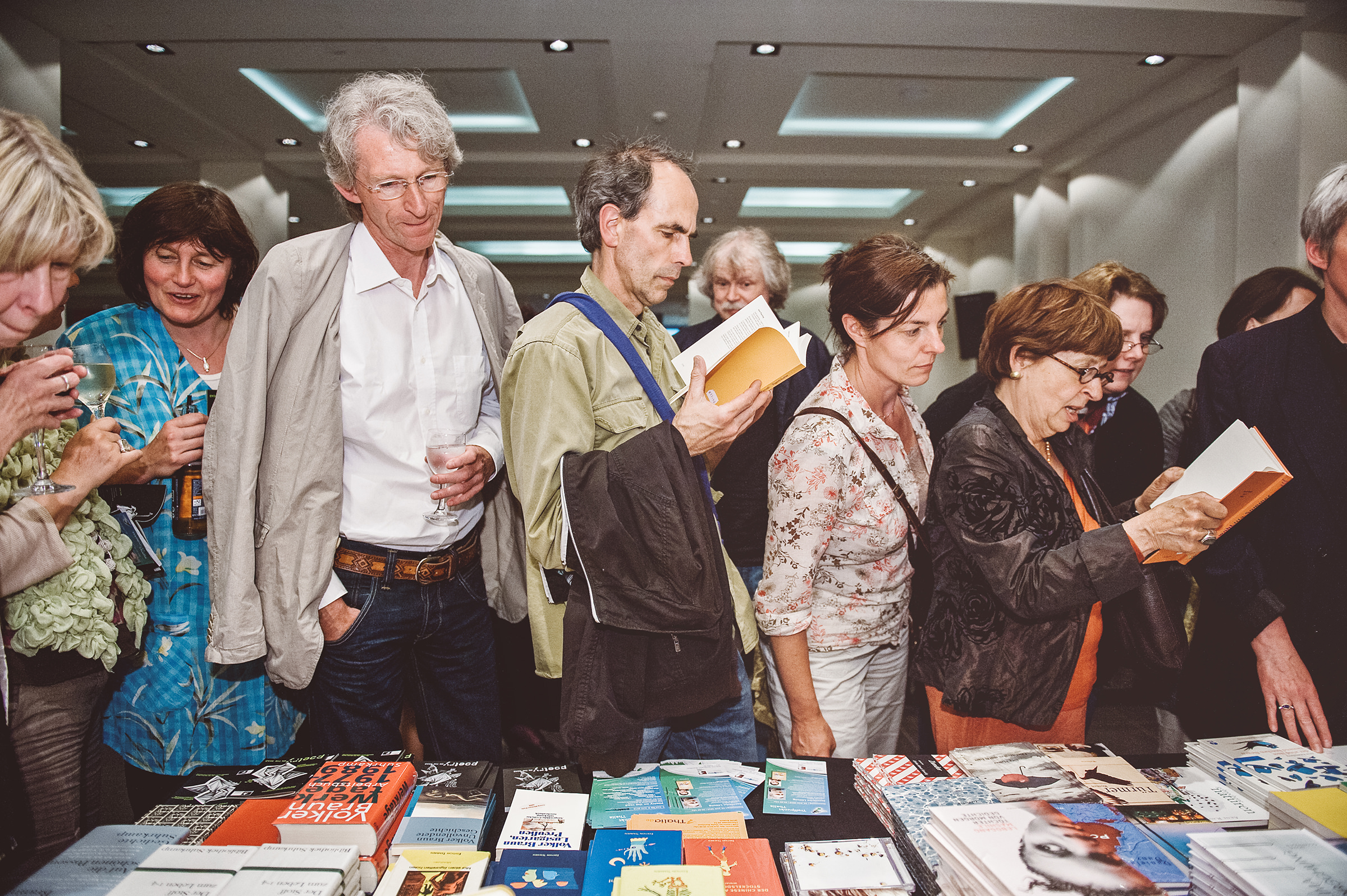 Event Fotografie von Besuchern und Teilnehmern des Internationalen Literaturfestivals Poetry On The Road in Bremen, die sich Bücher anschauen