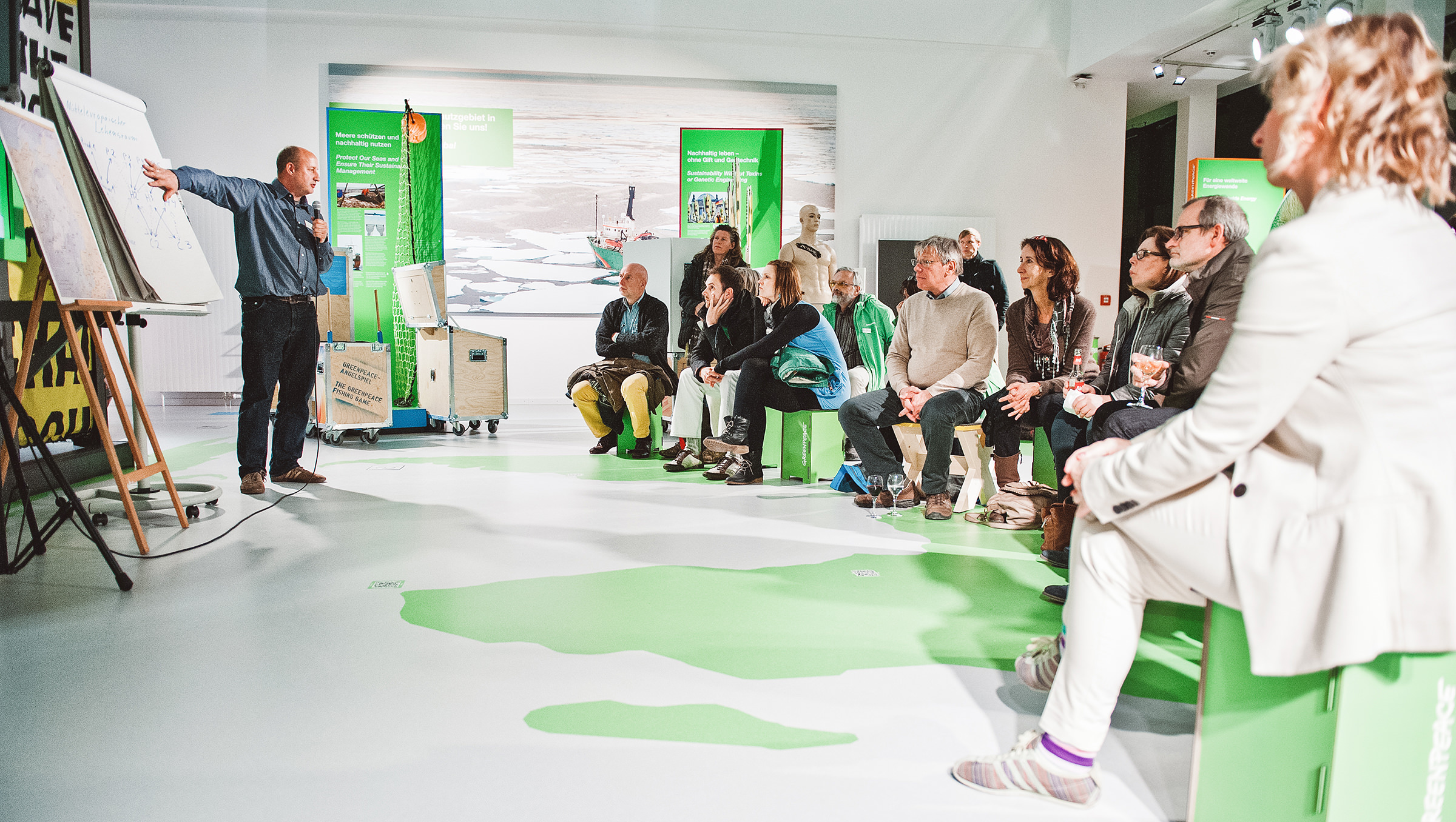 Ein Experte diskutiert mit dem Publikum bei einer Greenpeace Veranstaltung in Hamburg, fotografiert von einem Veranstaltungsfotografen