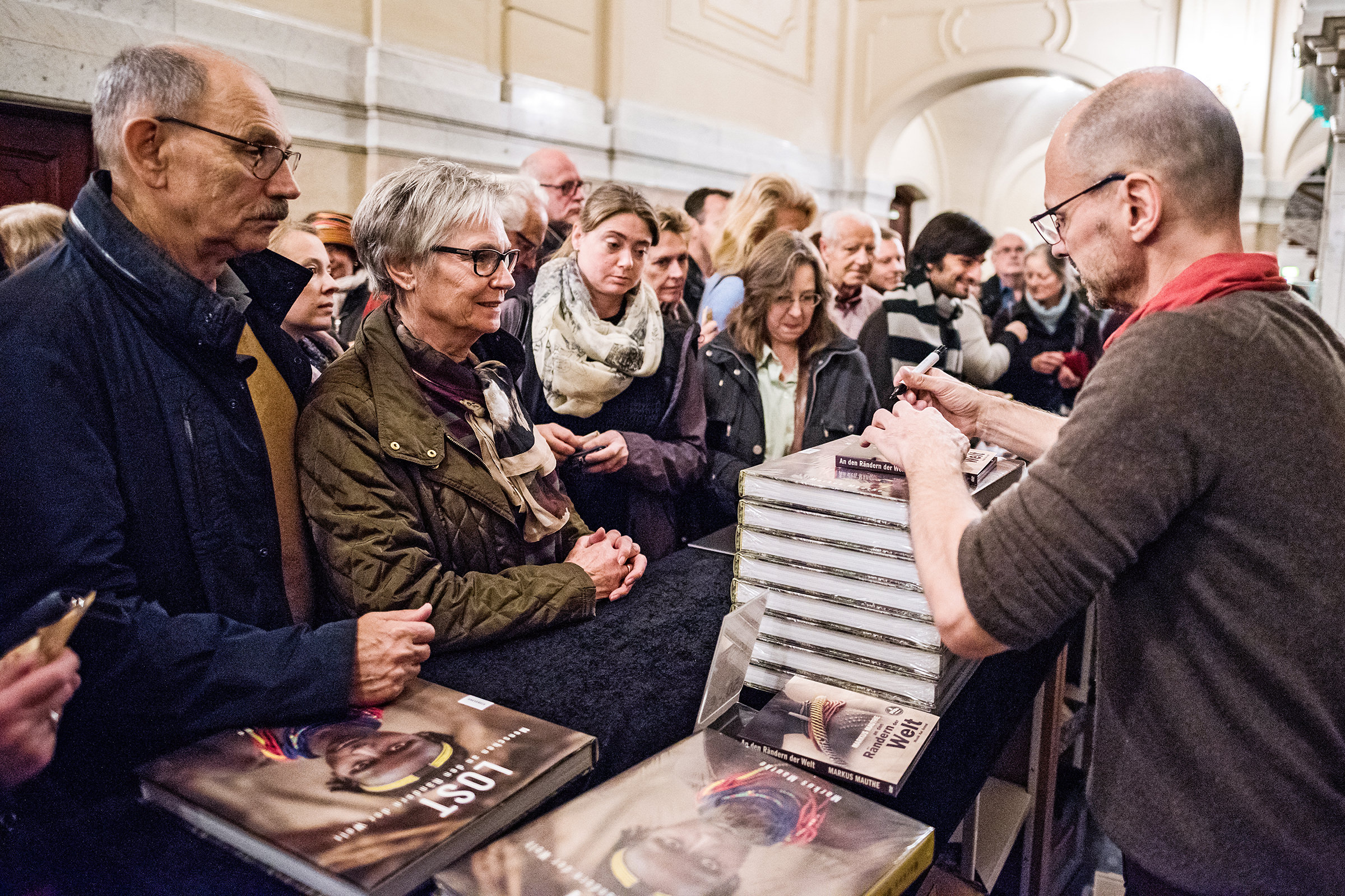 Ein Fotograf unterschreibt seine Bücher im Rahmen einer Veranstaltung in der Laeiszhalle in Hamburg