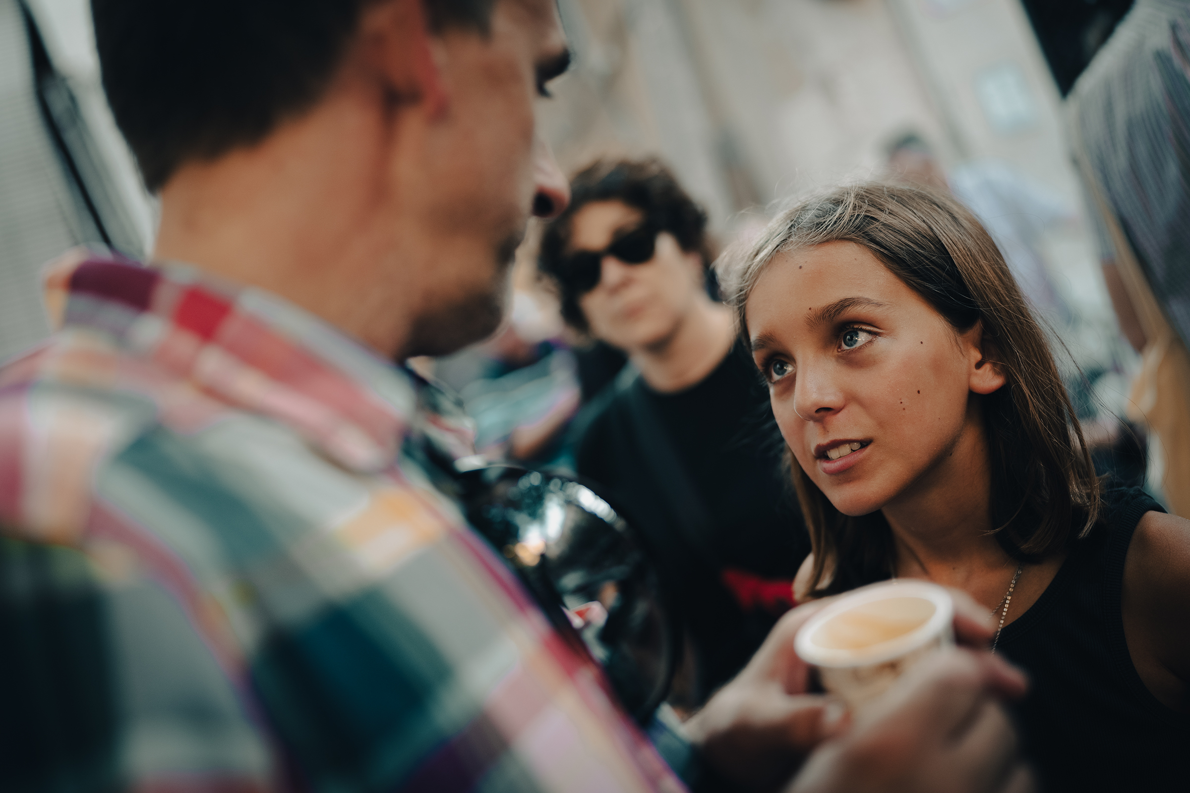 This captivating documentary family photograph focuses on a young girl engaged in earnest conversation with an adult, beautifully capturing an authentic moment of family connection.